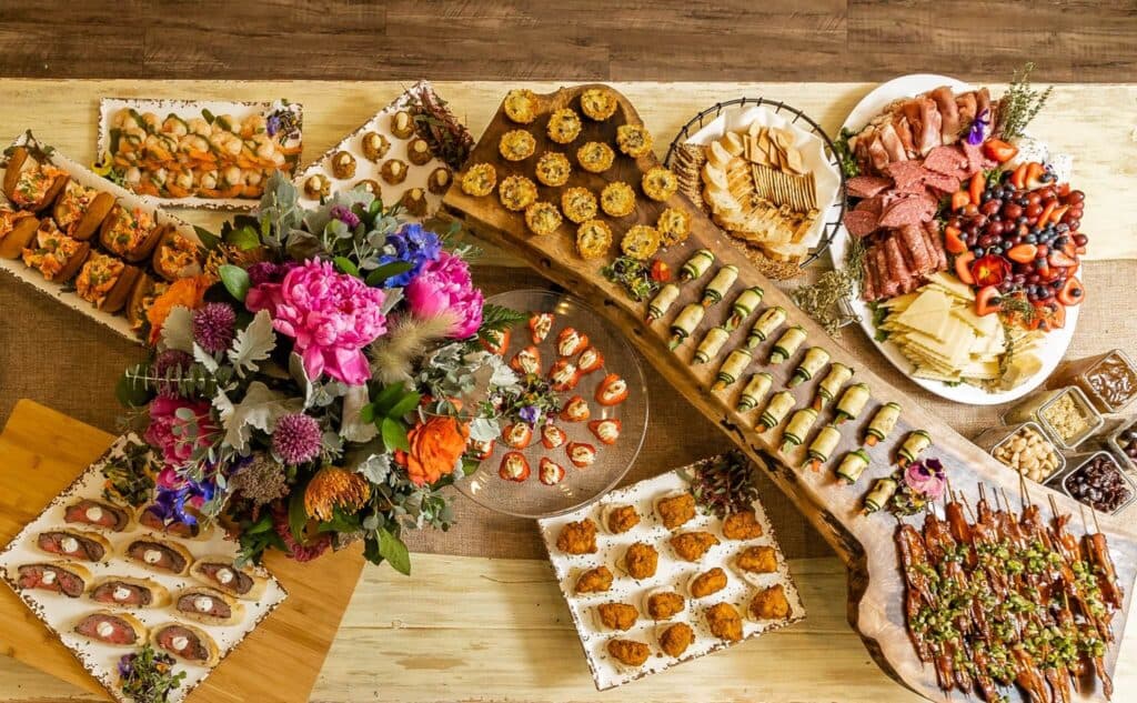 Assorted catered appetizer platters with fresh flowers